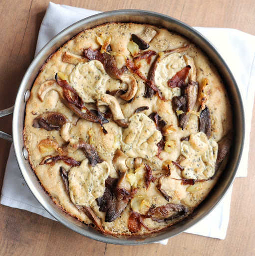 A round pizza pie topped with carmelized mushrooms and piles of delicious NONA Alfredo sauce.