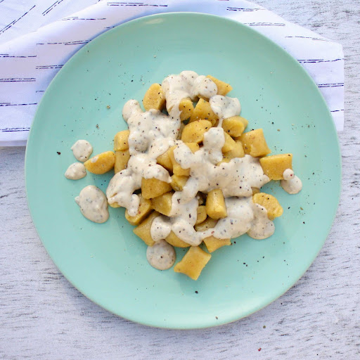 Piles of pillow-y pumpkin gnocchi are drizzled with NONA's Vegan Alfredo sauce.
